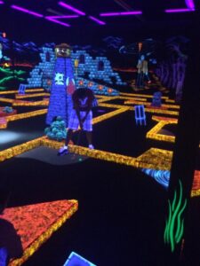 Glow-in-the-dark mini golf player used as a representative image for GLO Mini Golf Riverside