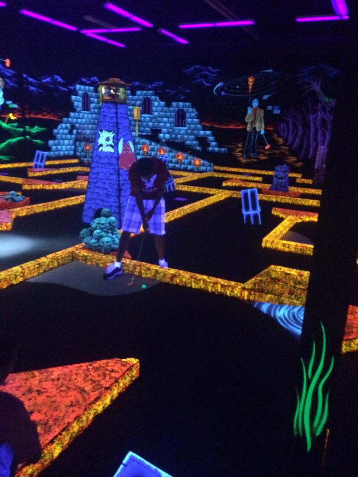 Glow-in-the-dark mini golf player used as a representative image for GLO Mini Golf Riverside