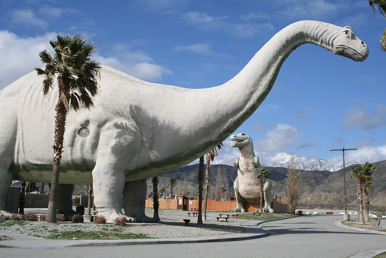Dinny the Dinosaur and Mr Rex at the Cabazon Dinosaurs with mountains behind them