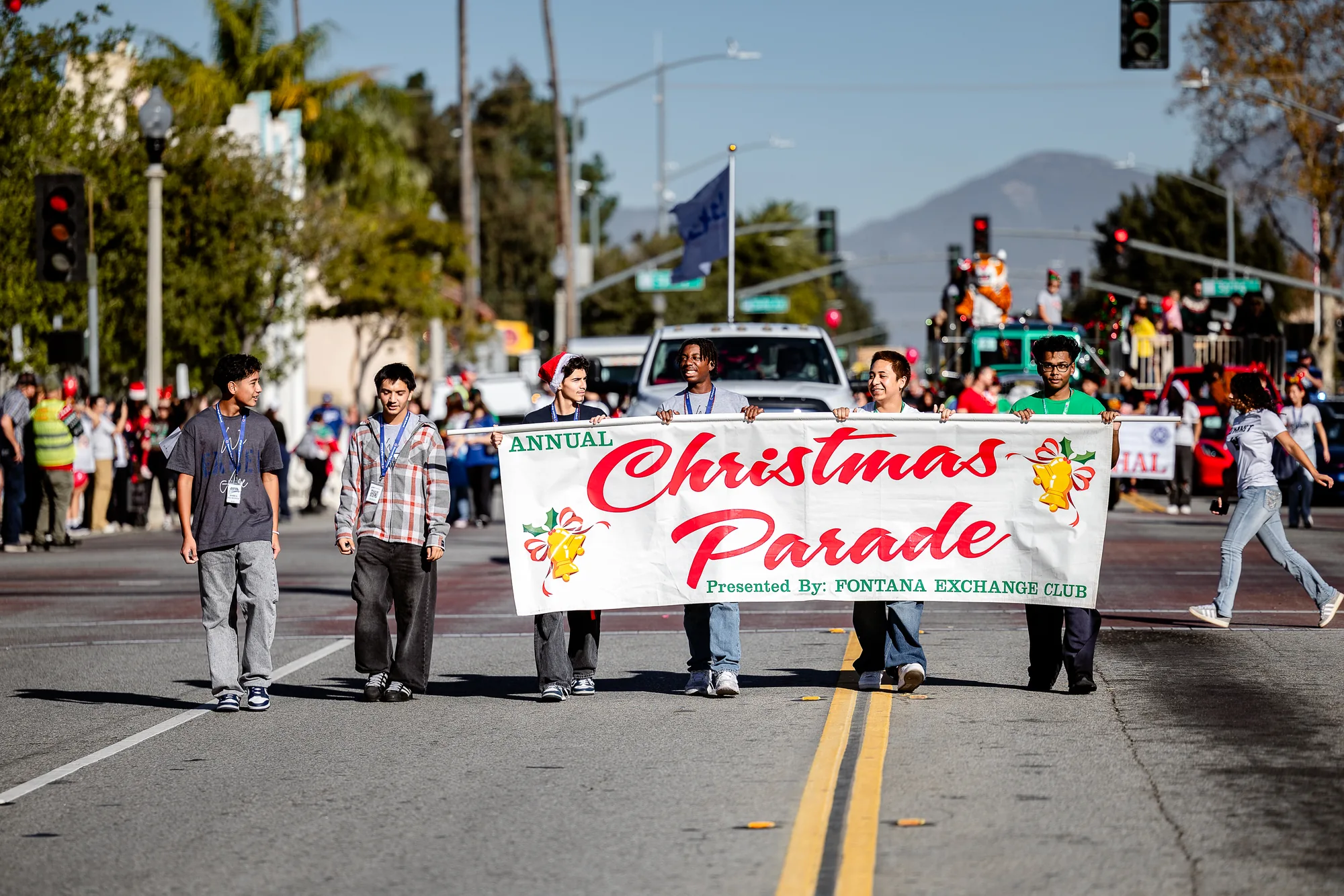 Volunteers carry the annual Fontana Christmas Parade banner down the street