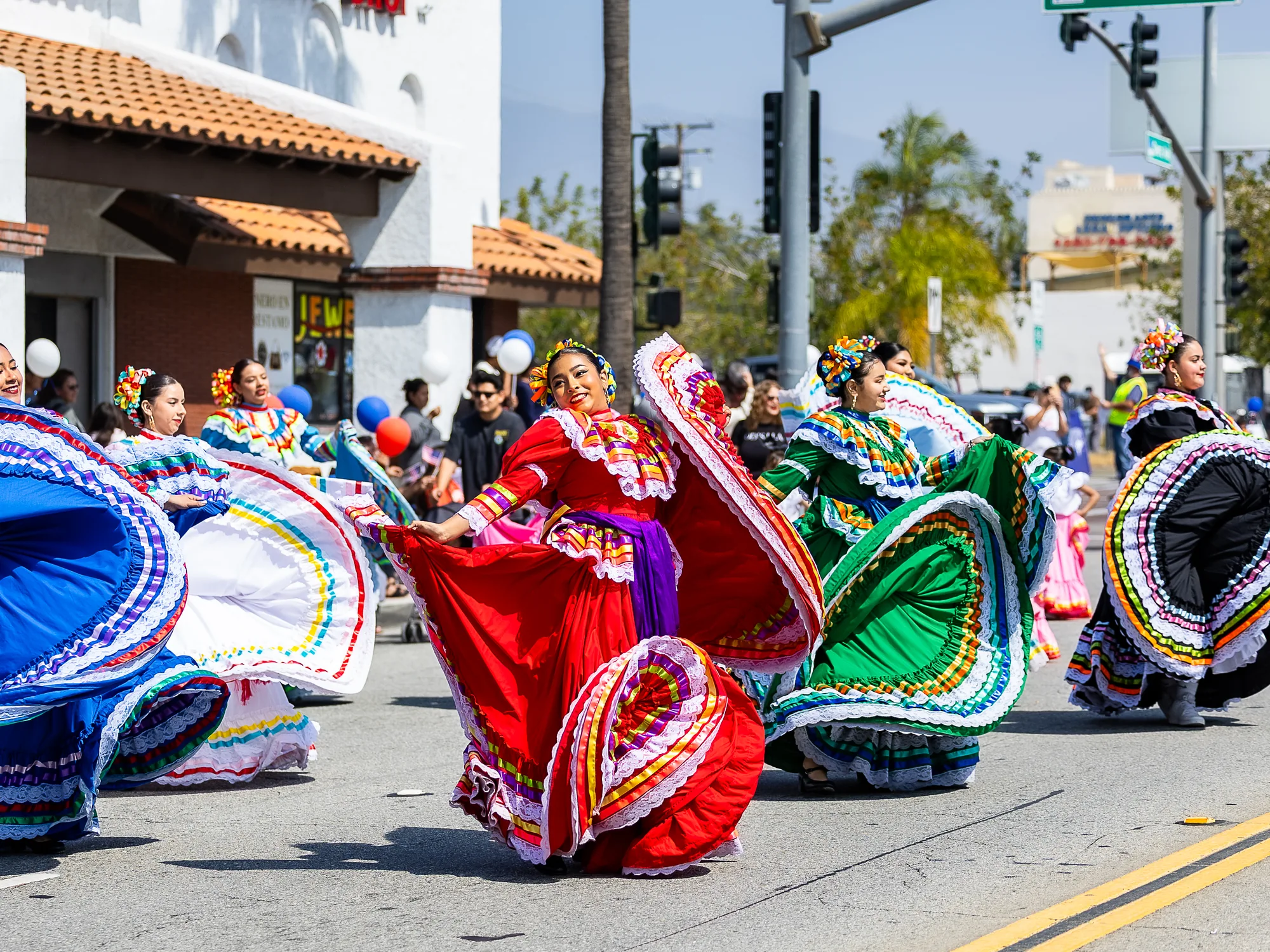 Folklórico dancers in colorful dresses perform on the Fontana Days Parade route