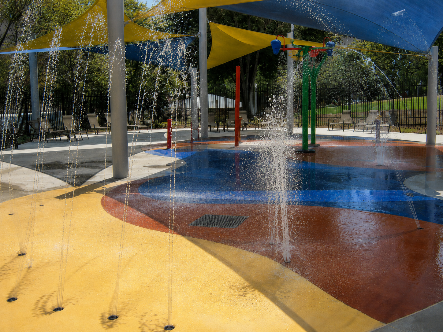 Splash pad spray features under shade sails at Martin Tudor Splash Park in Fontana