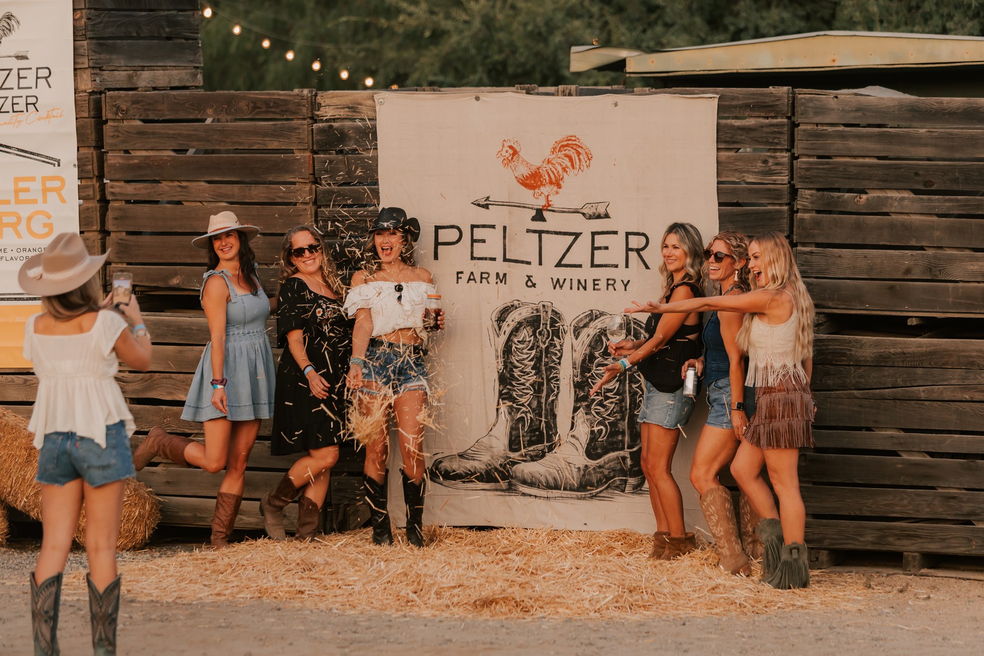 Guests posing beside the Peltzer Farm and Winery sign at Nashville Nights