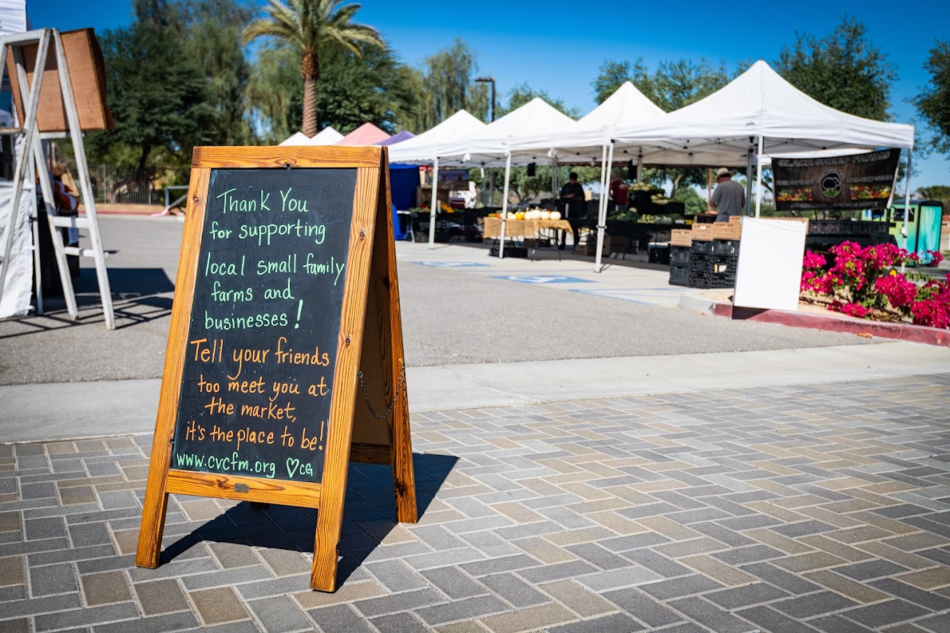 Vendor canopies and welcome board at Rancho Mirage Certified Farmers Market