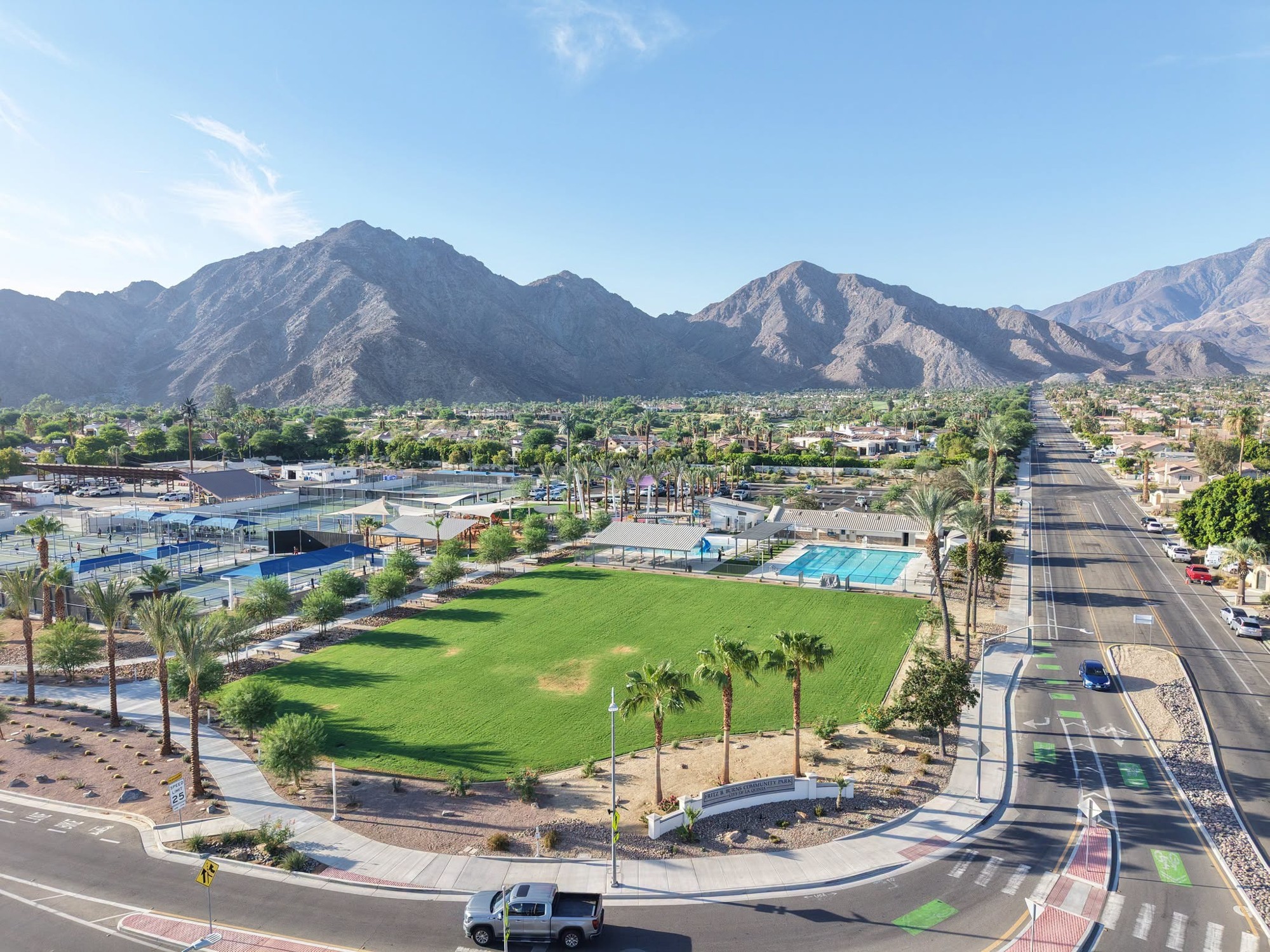 Aerial view of Fritz Burns Park with courts, pool and mountain backdrop